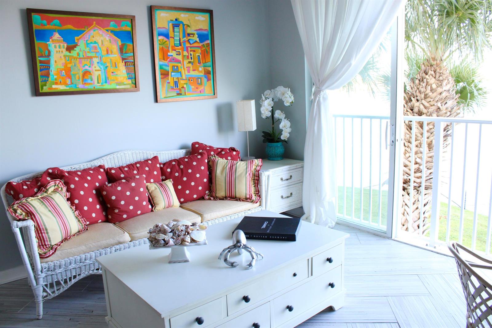A living room features a white wicker sofa with red polka-dot pillows and a coffee table — 3 E Harbour Isle Drive E # 204, Fort Pierce FL 34949, FORT PIERCE, FL