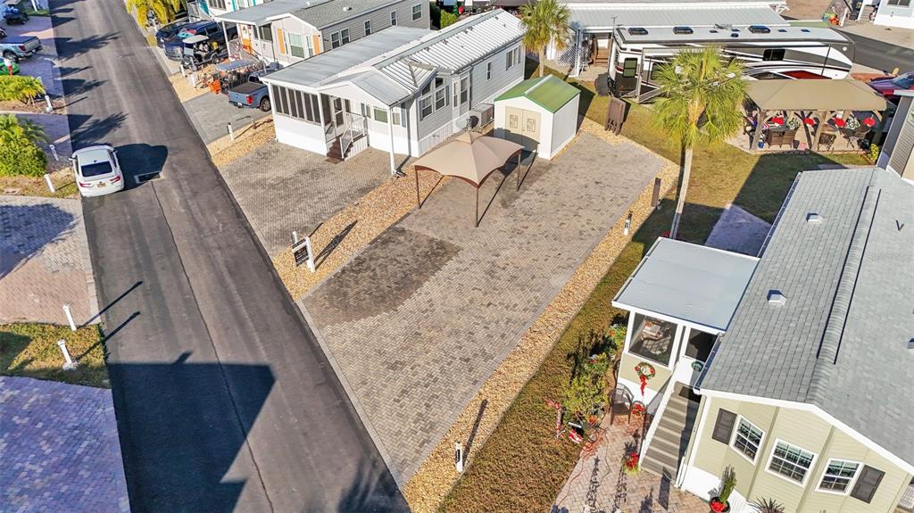 An aerial view shows a manufactured home with a paved driveway, gazebo, and storage shed — 2436 CITRUS TREE ROAD, CLERMONT, FL