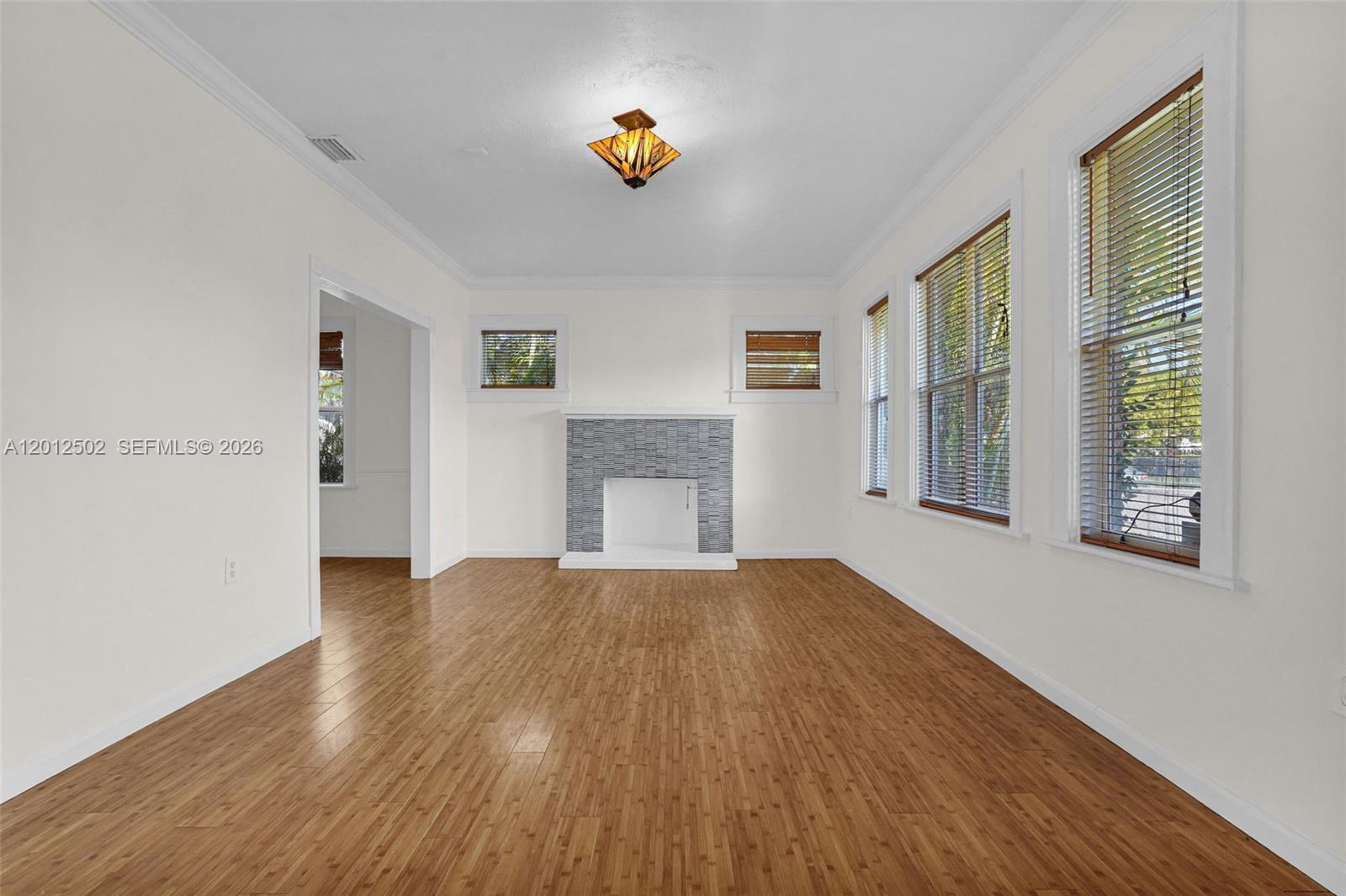 A living room features light wood floors, white walls, and a tiled fireplace — 126 NW 48th St # 0, Miami FL 33127, MIAMI, FL