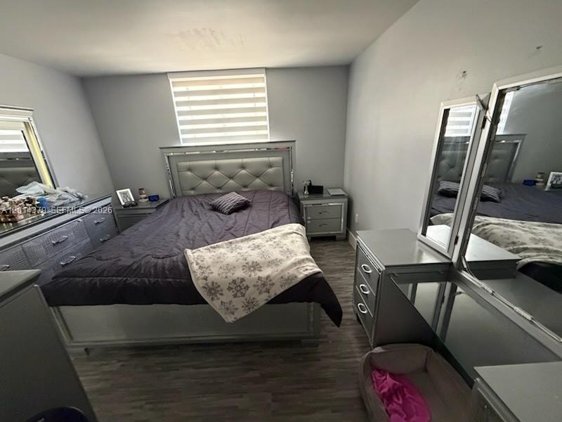 A bedroom features a tufted silver bed frame, matching dressers, and wood-look flooring — 5033 NW 7th St # 209, Miami FL 33126, MIAMI, FL