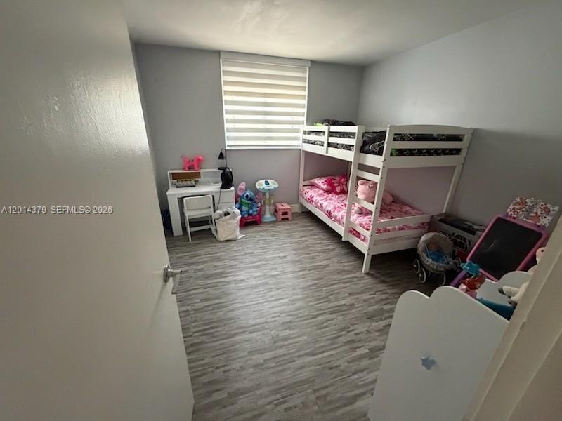 A bedroom features a white bunk bed, a desk, and wood-look flooring — 5033 NW 7th St # 209, Miami FL 33126, MIAMI, FL