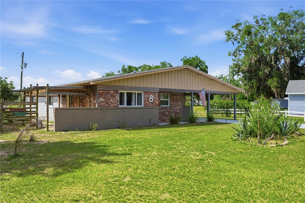 A single-story house with a brick facade, a covered carport, and a wooden pergola — 8 SILVER WAY, OCALA, FL