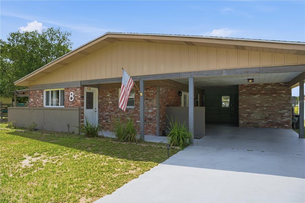A single-story house with a brick facade, a front porch, and an attached carport — 8 SILVER WAY, OCALA, FL