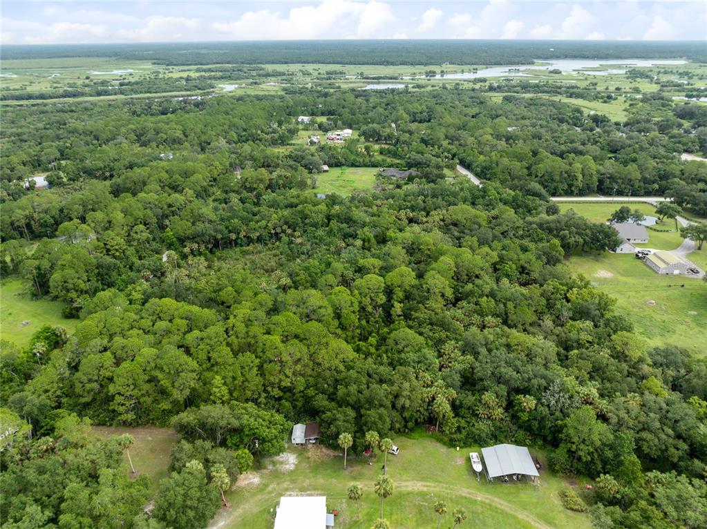 An aerial view shows a large, wooded lot with several small buildings and structures — 2750 PERCH ROAD, GENEVA, FL