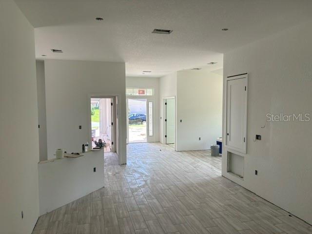 An interior view of a room under construction with light-colored tile flooring and white walls — 7722 SW 180TH CIRCLE, DUNNELLON, FL