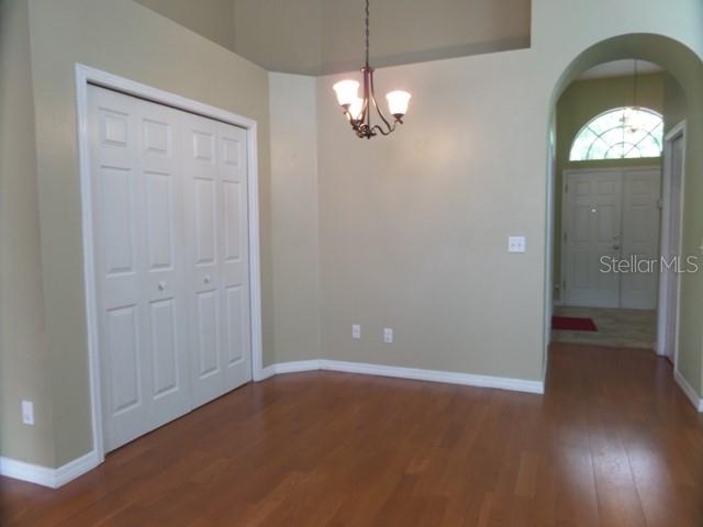 A room with hardwood floors, a white closet, and a chandelier, leading to an entryway — 2631 FALLBROOK DRIVE, OVIEDO, FL