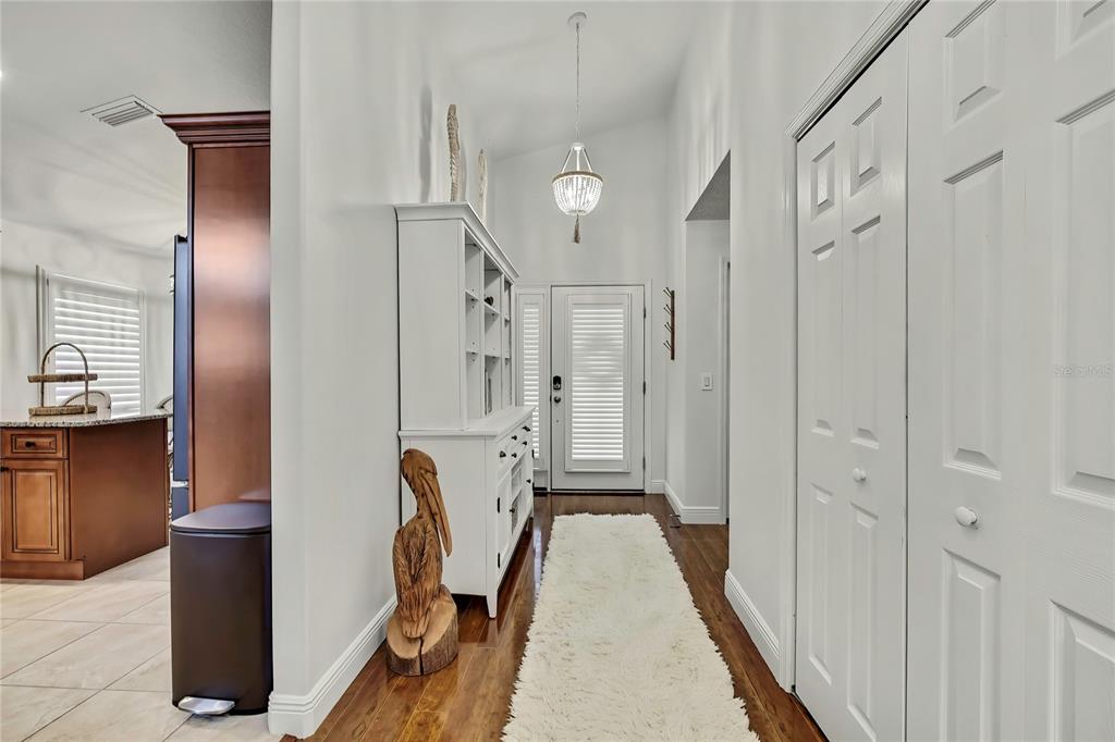 An entryway features a white hutch, a white rug on wood flooring, and a chandelier — 11956 W BLUE BAYOU COURT, CRYSTAL RIVER, FL