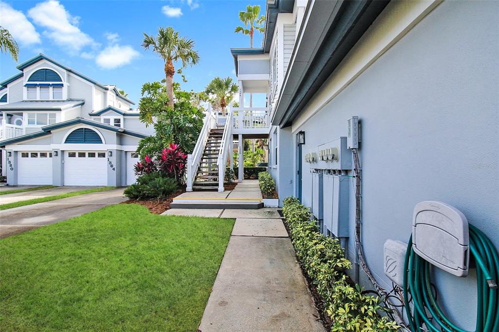 An exterior view of a multi-story residential building with a concrete walkway and outdoor staircase — 1338 SIESTA BAYSIDE DRIVE UNIT 1338-C, SARASOTA, FL