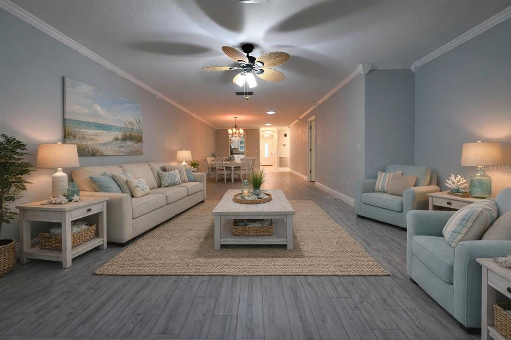A living room with light blue walls, wood-look flooring, a sofa, and two armchairs — 350 BOCA CIEGA POINT BLVD, ST PETERSBURG, FL