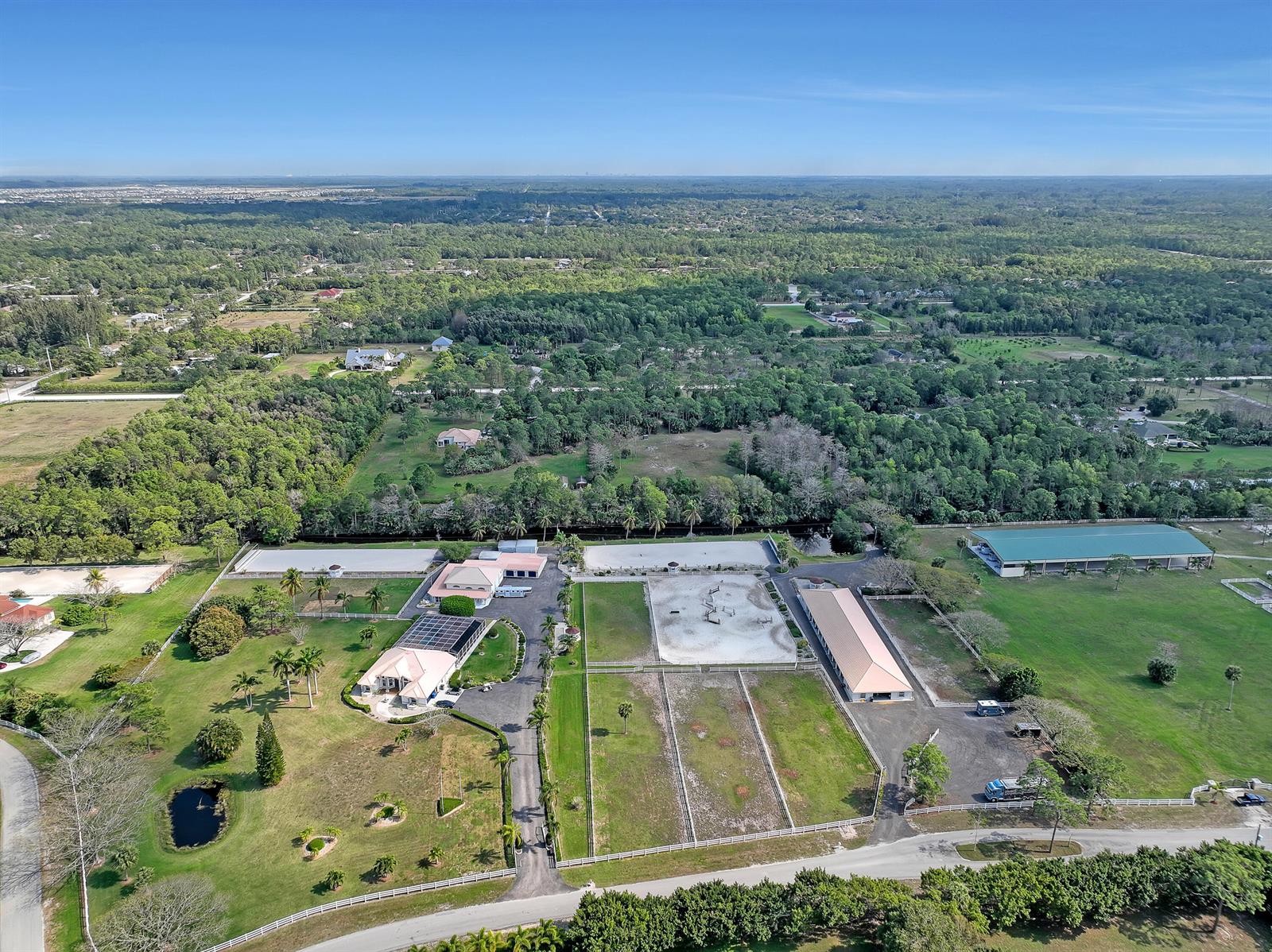 An aerial view shows an equestrian property with stables, riding arenas, and a residential house — 3426 &3406 Hanover Circle, Loxahatchee FL 33470, LOXAHATCHEE, FL