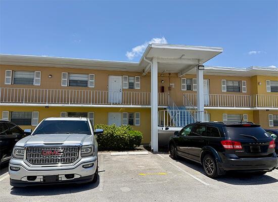 A two-story apartment building with a beige exterior and a covered entrance walkway — 1505 CRESCENT Circle # A12, Lake Park FL 33403, LAKE PARK, FL