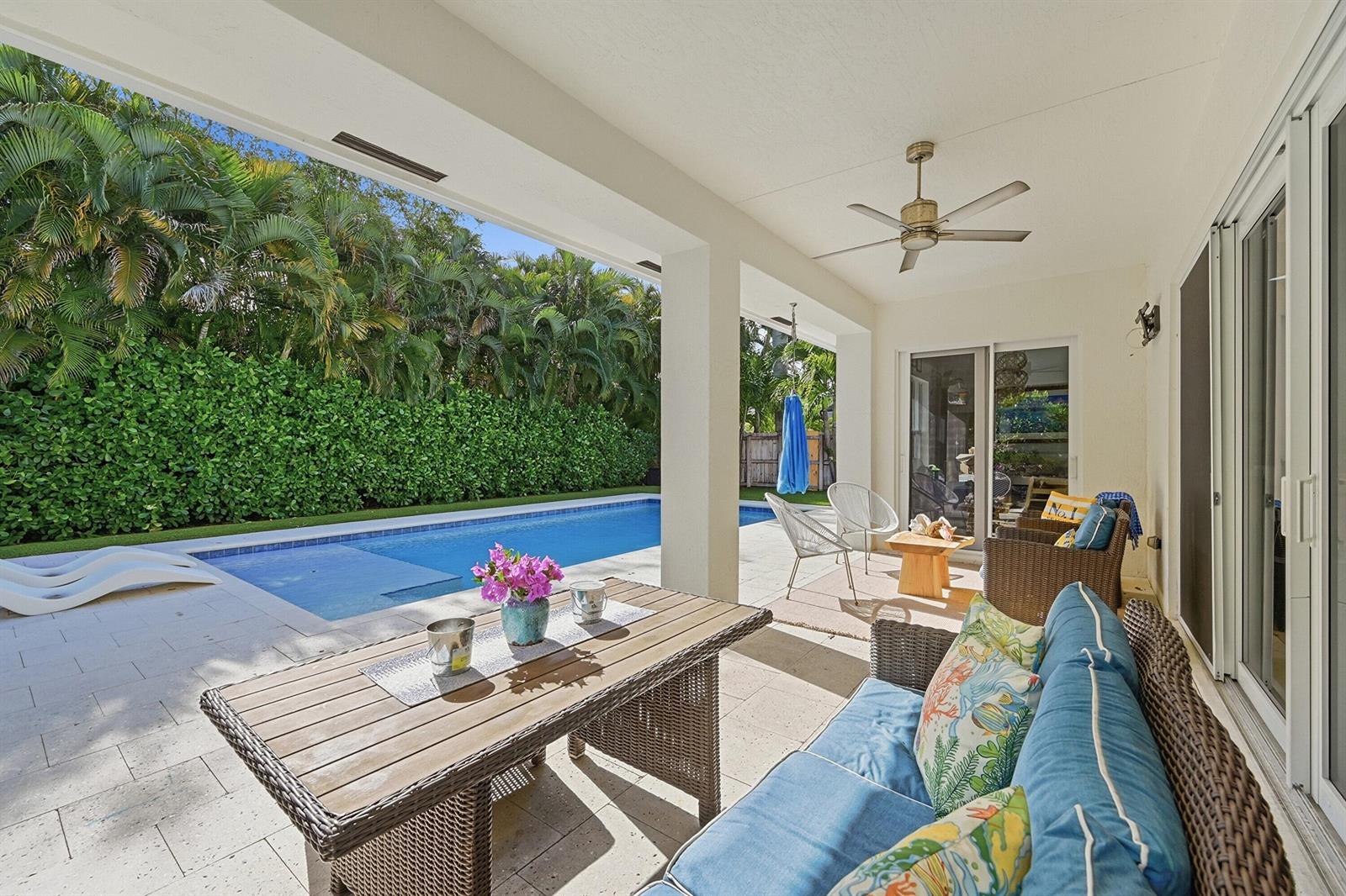 A covered patio features a dining table, outdoor sofa, and a swimming pool with landscaping — 2840 NE 22nd Avenue, Lighthouse Point FL 33064, LIGHTHOUSE POINT, FL