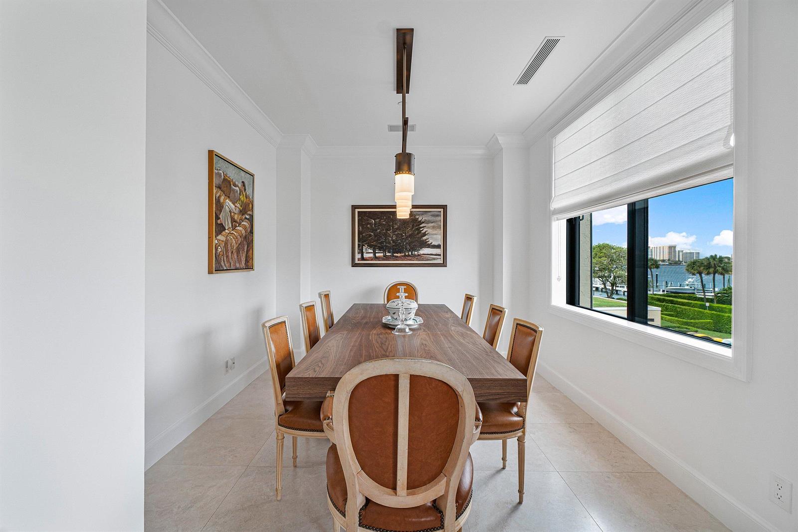 A dining room features a wooden table, leather chairs, and a large window with water views — 150 Bradley Place # 203, Palm Beach FL 33480, PALM BEACH, FL