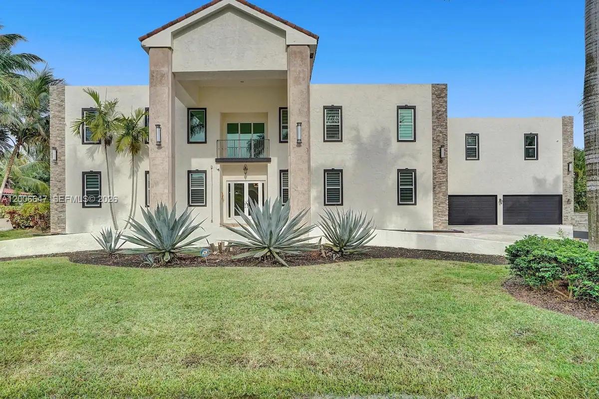 A large, two-story stucco house features a central entryway, dark-framed windows, and a two-car garage — 1430 NW 114th Ave, Plantation FL 33323, PLANTATION, FL