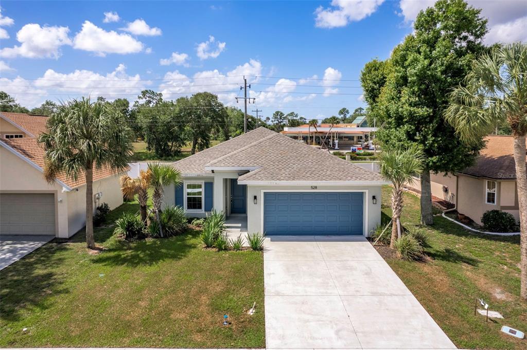 An aerial view of a single-story house with a blue garage door and palm trees — 528 ROSE APPLE CIRCLE, PORT CHARLOTTE, FL
