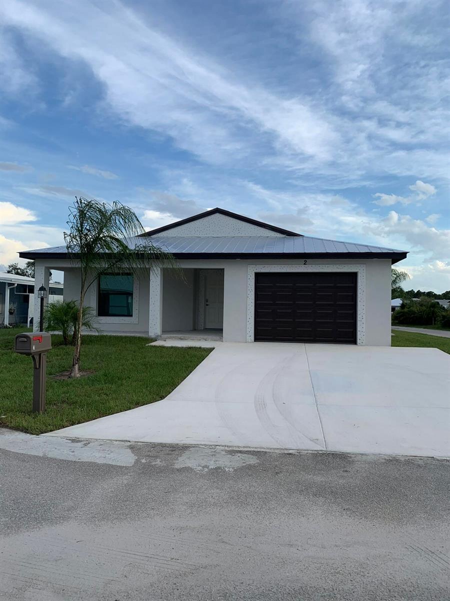 A single-story house with a metal roof, gray exterior, and a one-car garage — 43 La Villa Way, Fort Pierce FL 34951, FORT PIERCE, FL