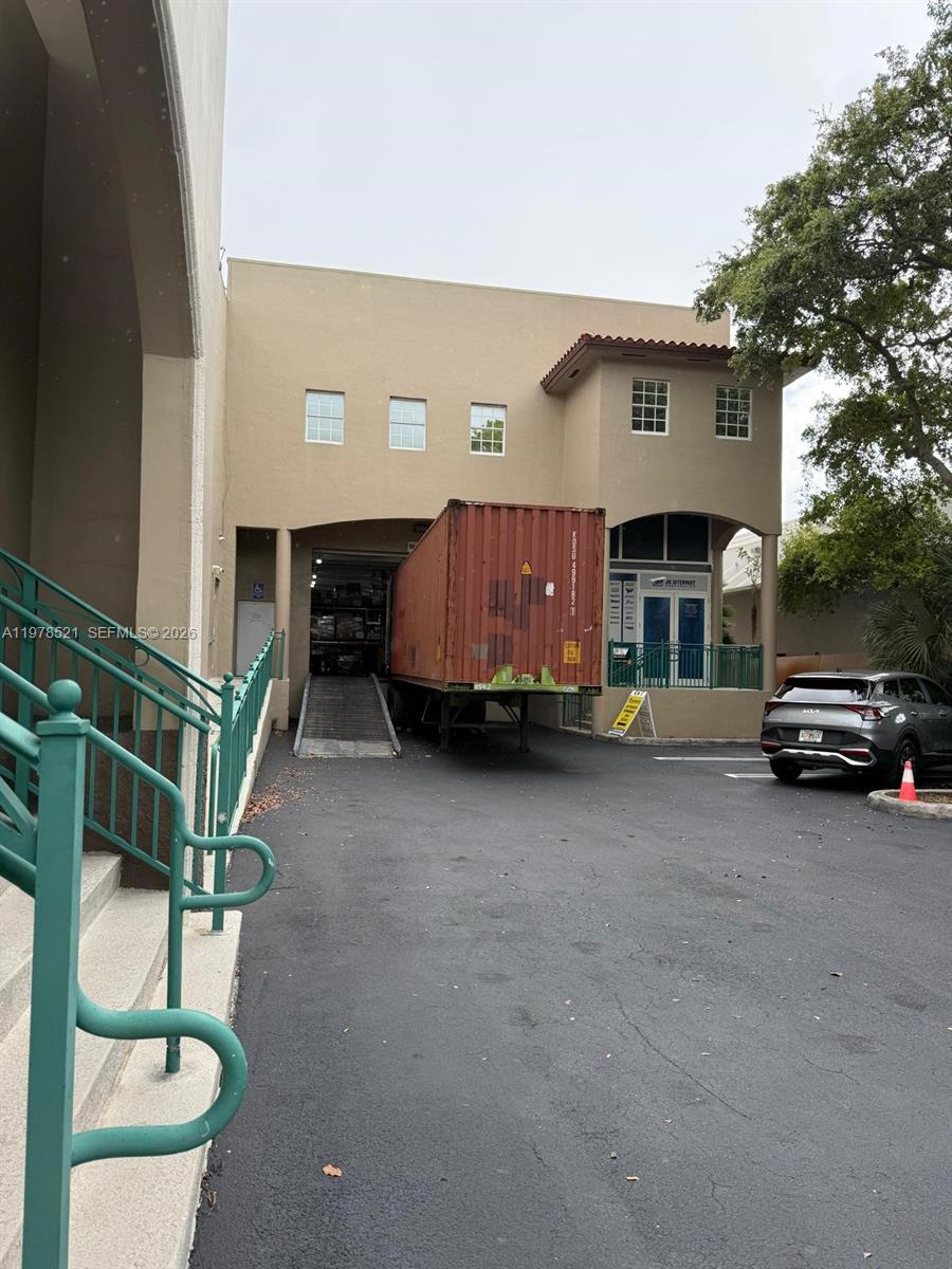 A shipping container is parked at the loading dock of a tan commercial building — 10200 NW 25th St # 113, Doral FL 33172, DORAL, FL