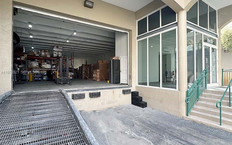 A warehouse loading dock with a metal grate ramp sits beside a glass-walled office entrance — 10200 NW 25th St # 113, Doral FL 33172, DORAL, FL