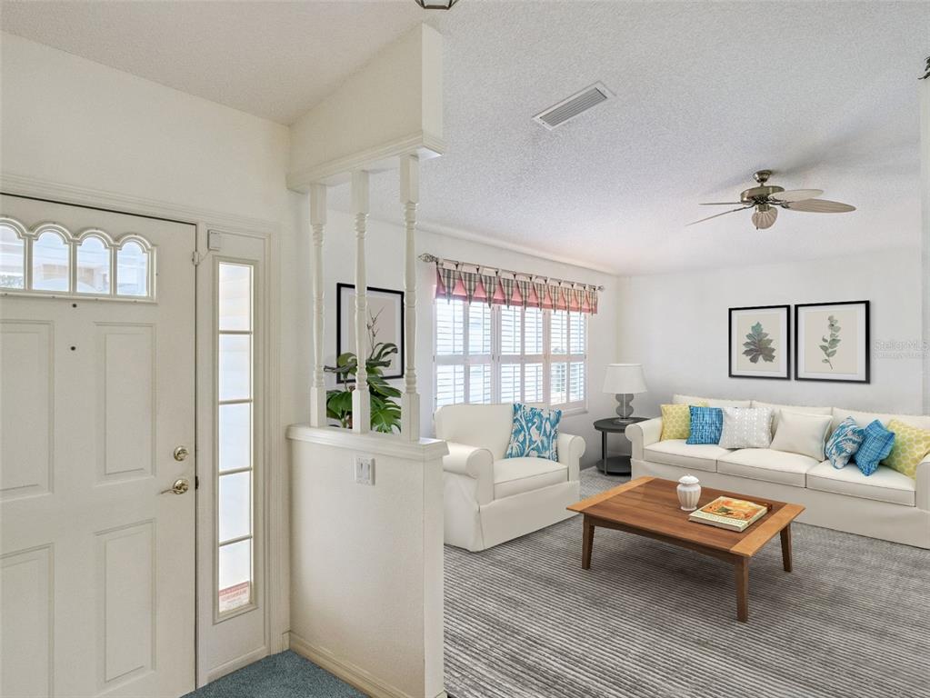 A living room features a half-wall with spindles, white furniture, and a wood coffee table — 21230 ROYAL ST GEORGES LANE, LEESBURG, FL