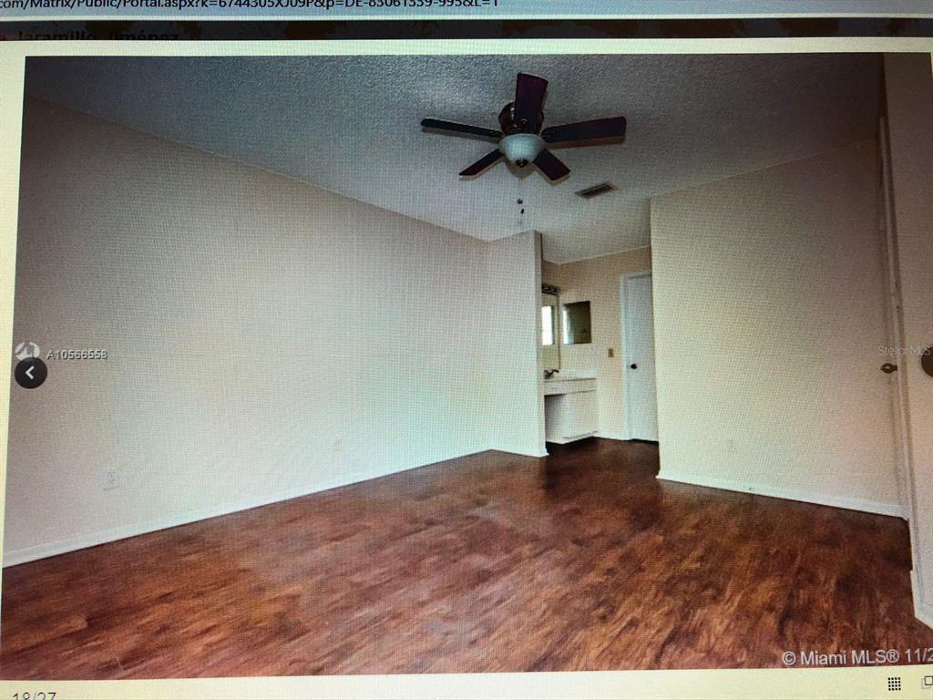 An empty room with wood-look flooring, a ceiling fan, and an attached vanity area — 1040 CORAL SPRINGS CLUB UNIT 1040, CORAL SPRINGS, FL