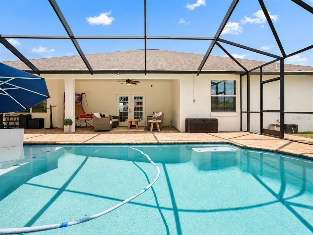 A screened-in patio features a swimming pool, outdoor seating, and a covered lanai area — 1939 GRIFFIN TRAIL, BARTOW, FL