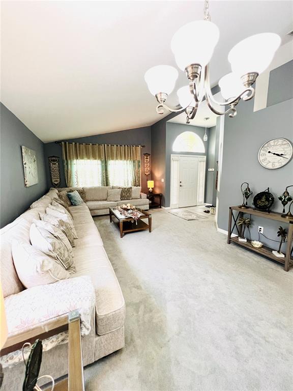 A living room features a large sectional sofa, a chandelier, and a console table — 2859 STAGS LEAP DRIVE, ORANGE CITY, FL