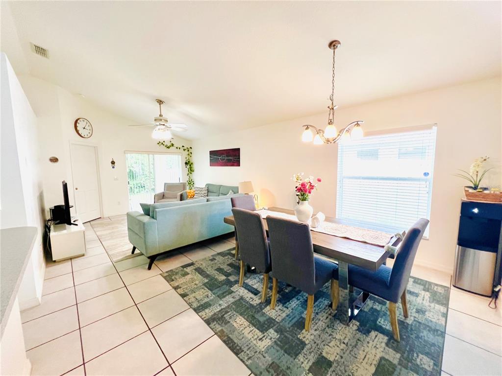 An open-concept living and dining area features tile flooring, a dining set, and a sofa — 2859 STAGS LEAP DRIVE, ORANGE CITY, FL