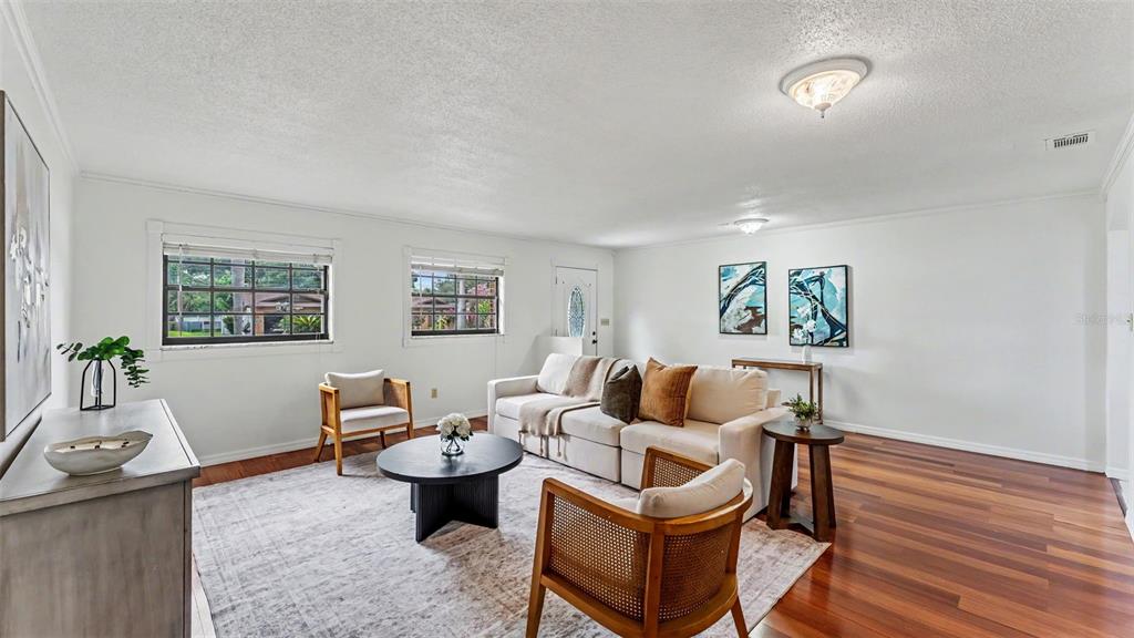 A living room features white walls, hardwood floors, a beige sofa, and two accent chairs — 4020 GLEN GARRY ROAD W, LAKELAND, FL