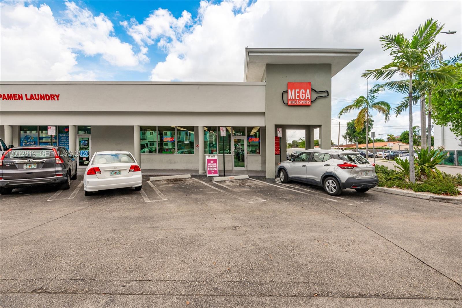An exterior view of a commercial building with a laundry business and a liquor store — 3941 NW 7 ST, Miami FL 33126, MIAMI, FL