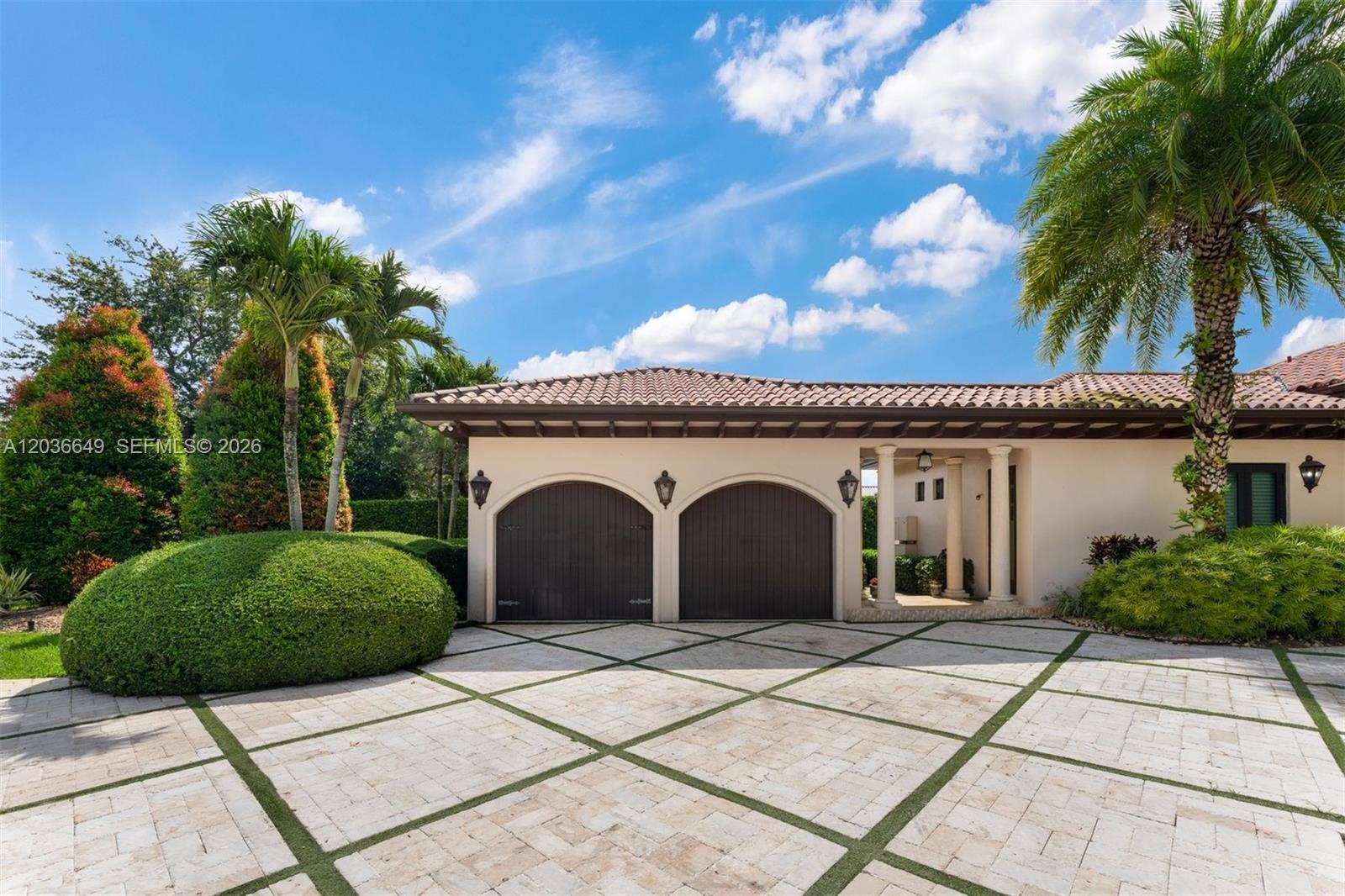 A beige house features a two-car garage with arched doors and a stone driveway — 10270 SW 62nd St, Miami FL 33173, MIAMI, FL