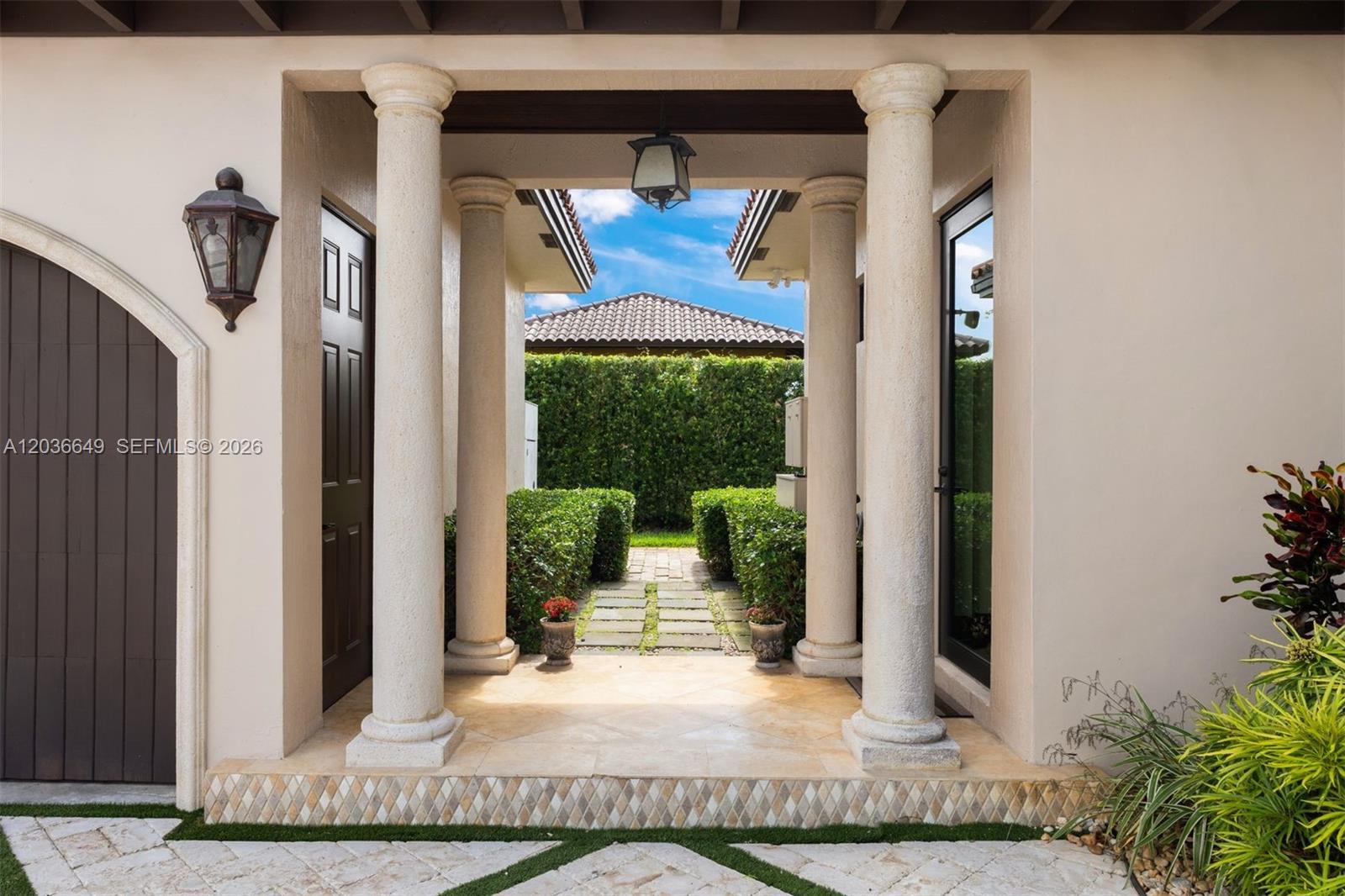 A covered entryway features two stone columns, a tiled floor, and a stone walkway — 10270 SW 62nd St, Miami FL 33173, MIAMI, FL