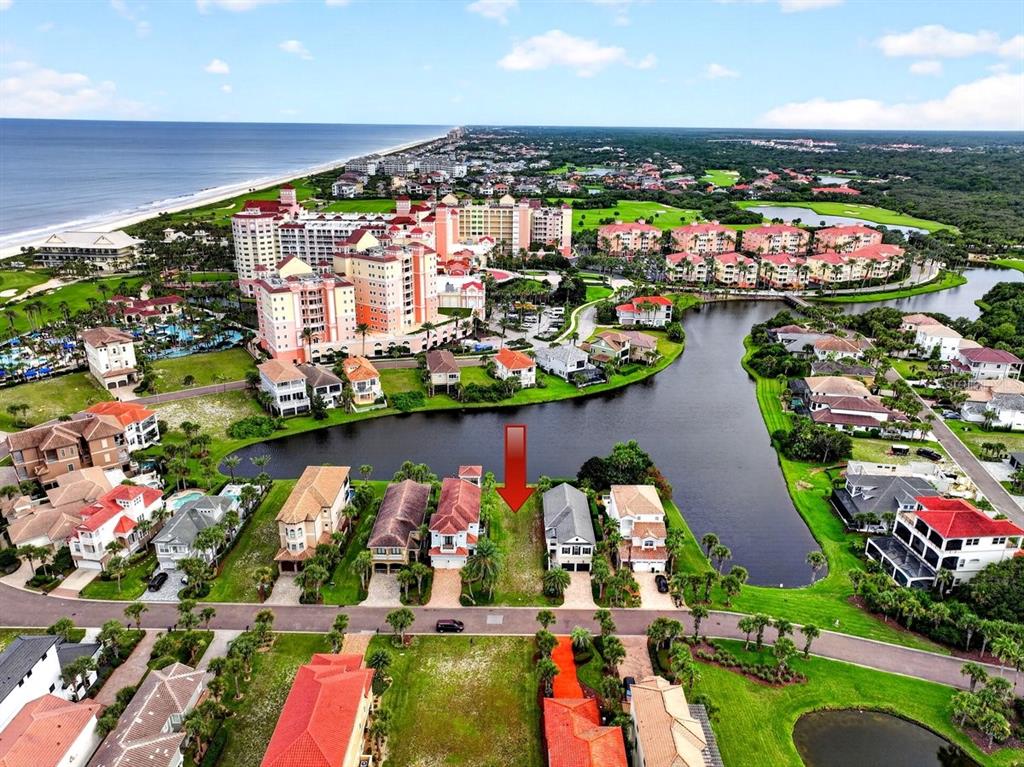 An aerial view shows a vacant residential lot situated between two houses near a lake — 41 NORTHSHORE AVENUE, PALM COAST, FL
