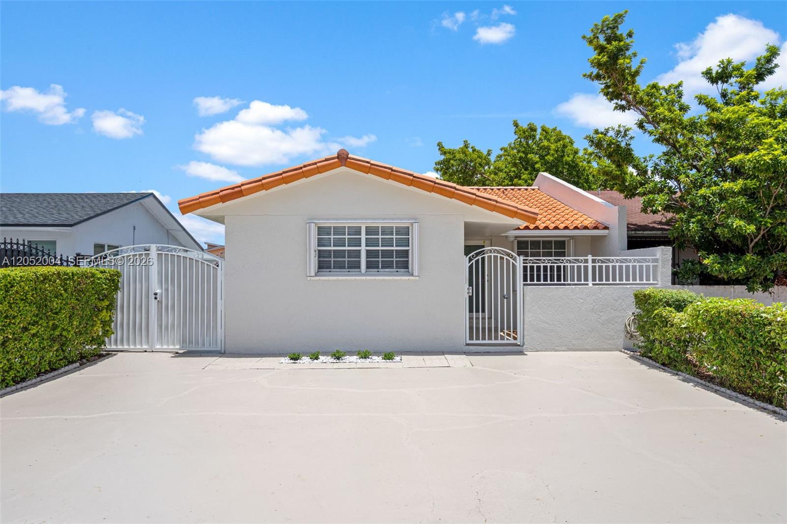 A single-story house with a white stucco exterior, orange tile roof, and a paved driveway — 1333 W 37th St, Hialeah FL 33012, HIALEAH, FL