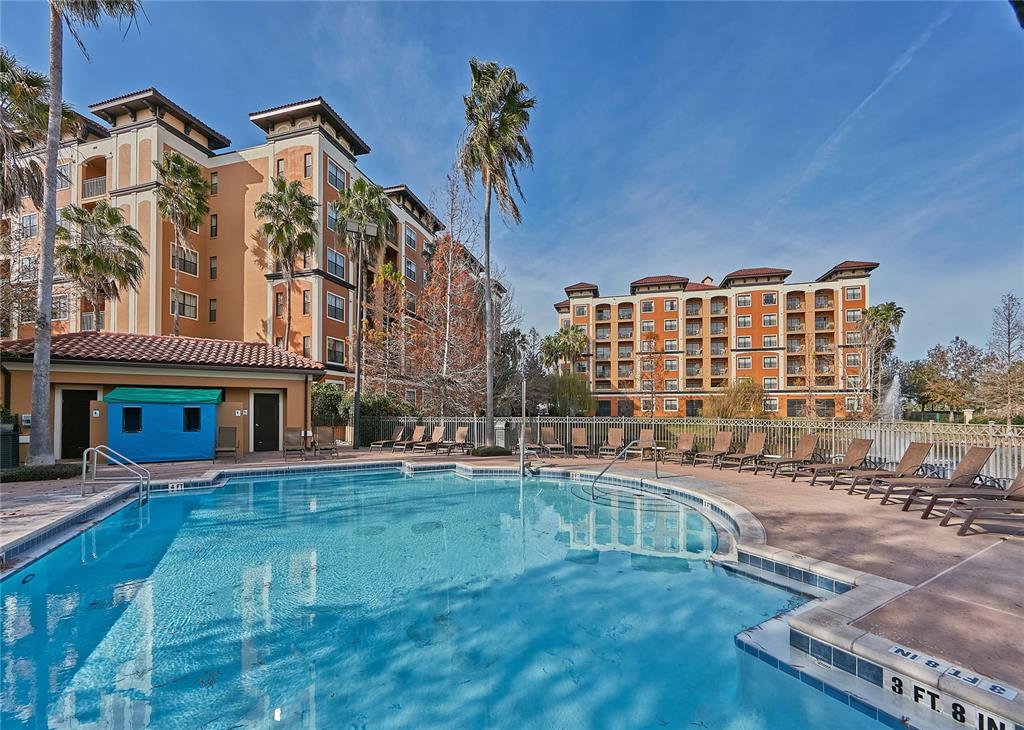 A swimming pool with lounge chairs sits in front of two large apartment buildings — 12527 FLORIDAYS RESORT DRIVE UNIT 605-E, ORLANDO, FL