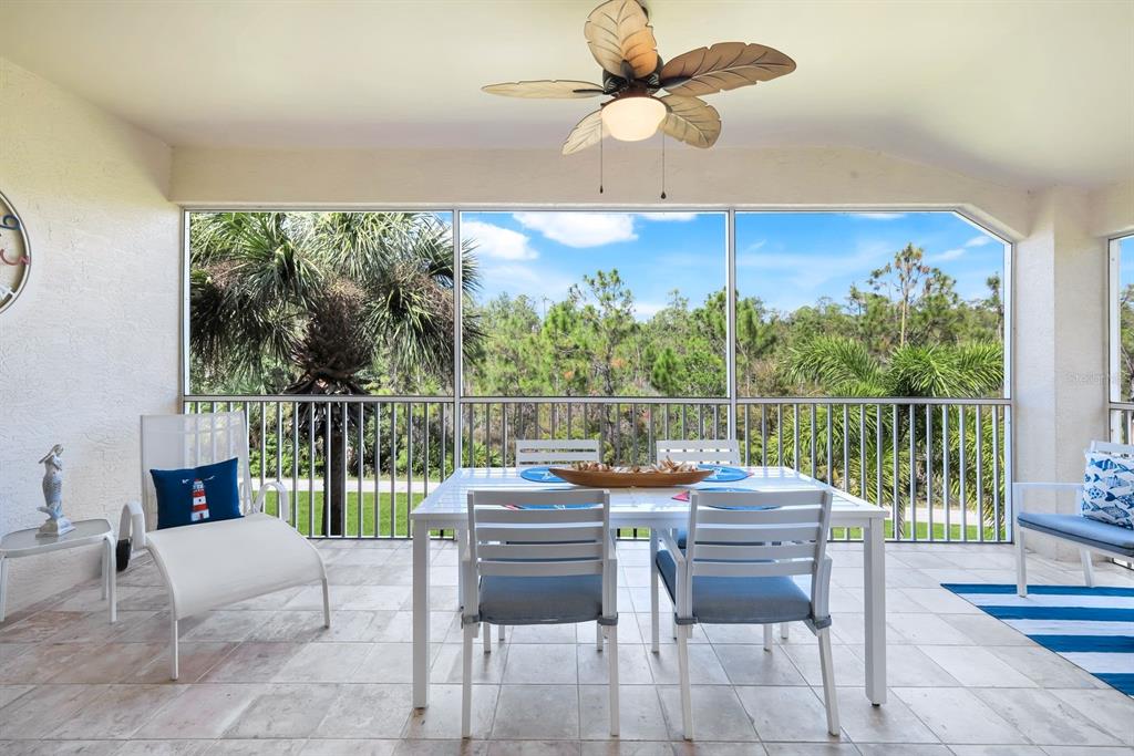 A screened-in patio features tile flooring, a ceiling fan, and outdoor dining furniture — 11019 MILL CREEK WAY UNIT 901, FORT MYERS, FL