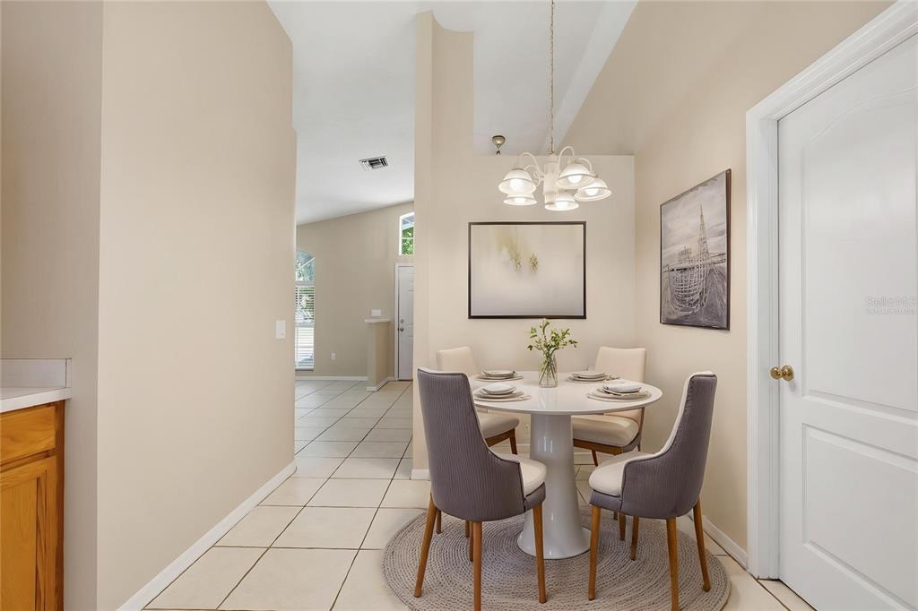 A dining nook features a round white table, four chairs, and a pendant light fixture — 3049 CASTLE ROCK CIRCLE, LAND O LAKES, FL