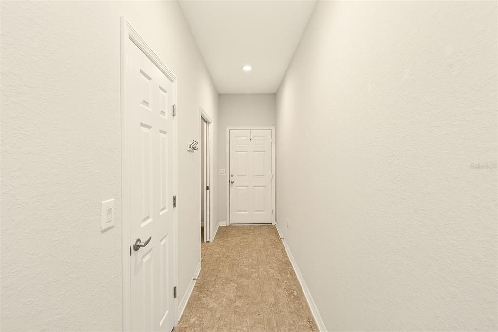 A narrow hallway features light-colored walls, tiled flooring, and white doors — 4680 VIGNETTE WAY, SARASOTA, FL