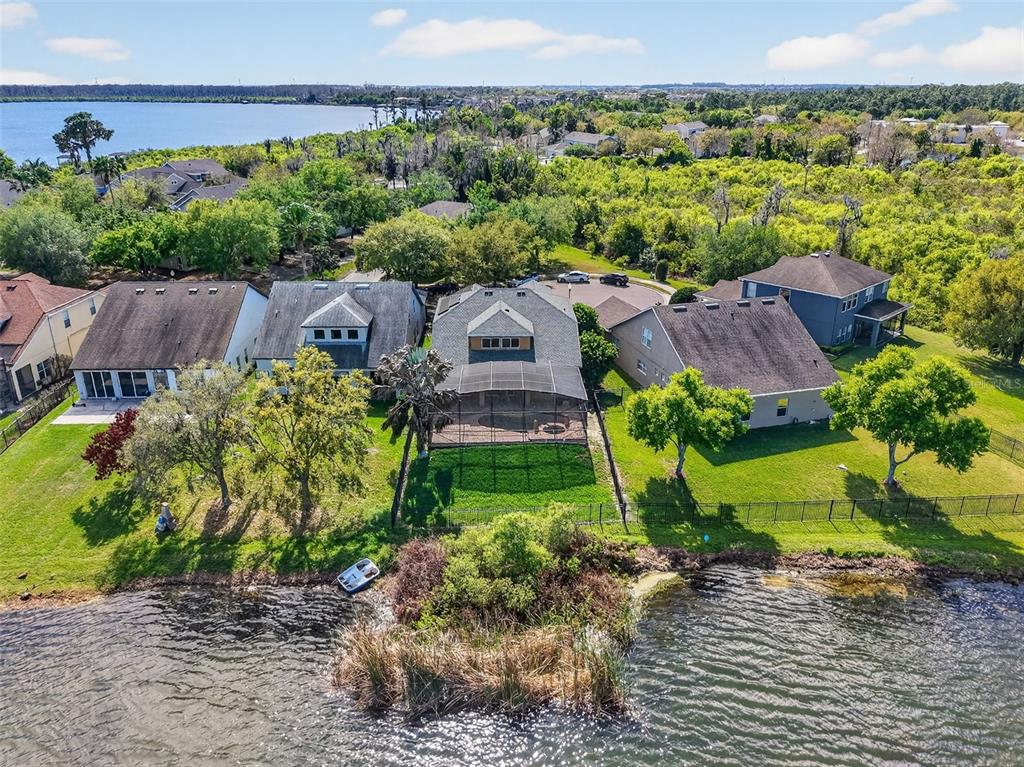 An aerial view shows several waterfront houses with screened-in pools and backyards facing a lake — 5413 WALSH POND COURT, WINDERMERE, FL