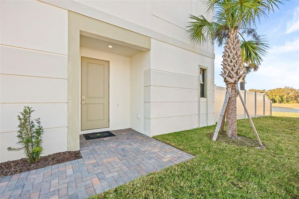 A paved walkway leads to a tan front door on the side of a building — 14506 STELLAR PLACE, LAKEWOOD RANCH, FL