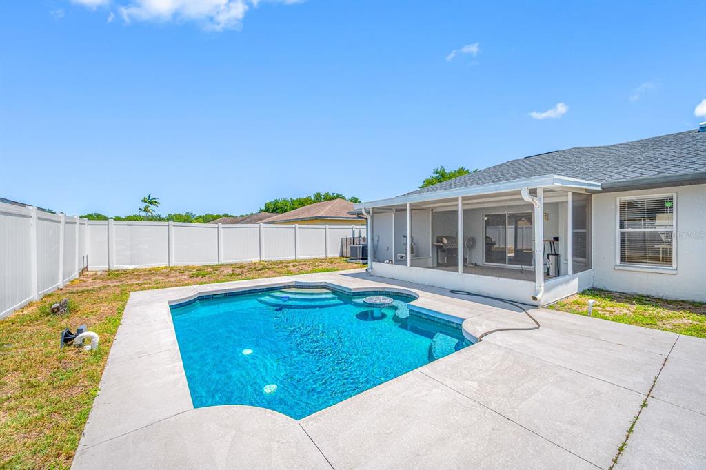 A backyard features a swimming pool, a screened-in patio, and a white vinyl privacy fence — 2802 93RD COURT E, PALMETTO, FL