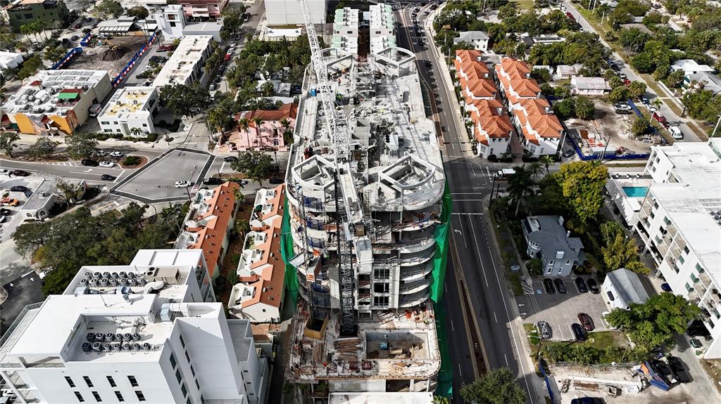 An aerial view shows a multi-story building under construction with a crane on site — 290 COCOANUT AVENUE UNIT 604, SARASOTA, FL