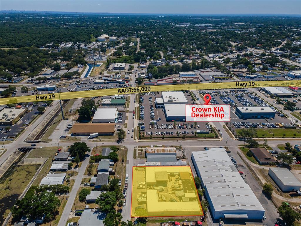 This aerial view shows a commercial property highlighted in yellow near a car dealership — 3580 66TH AVENUE N, PINELLAS PARK, FL