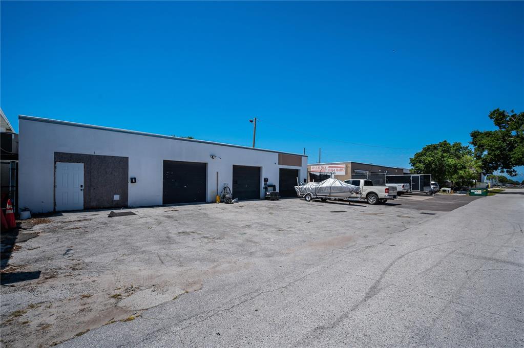 A low-rise commercial building with three roll-up doors and a parking lot — 3580 66TH AVENUE N, PINELLAS PARK, FL