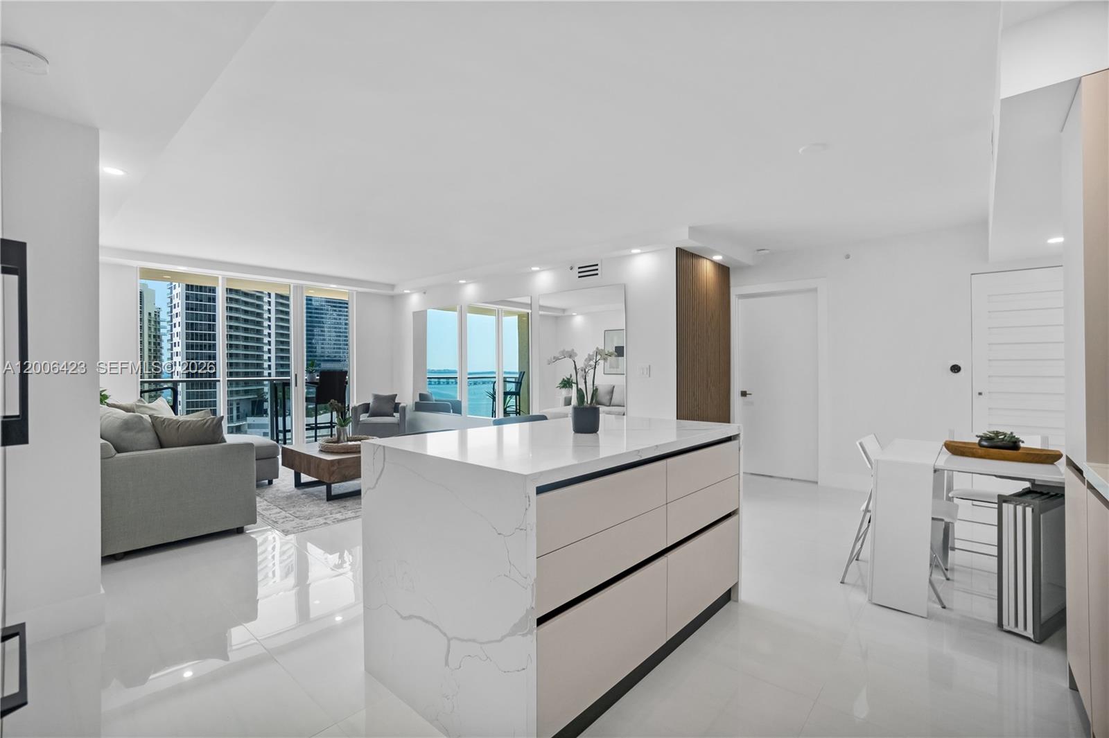 A modern kitchen island with a marble countertop sits in an open-concept living area — 1155 Brickell Bay Dr # 2003, Miami FL 33131, MIAMI, FL