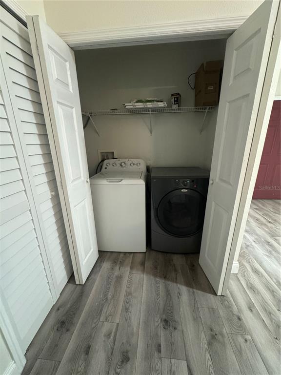 A laundry closet contains a white top-load washer and a dark gray front-load dryer — 2880 CLUB CORTILE CIRCLE UNIT B, KISSIMMEE, FL