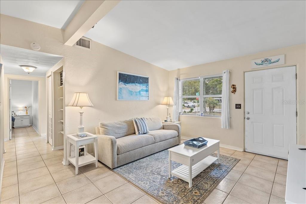 A living room features a beige sofa, a white coffee table, and tile flooring — 450 CARD AVENUE, HOLLY HILL, FL