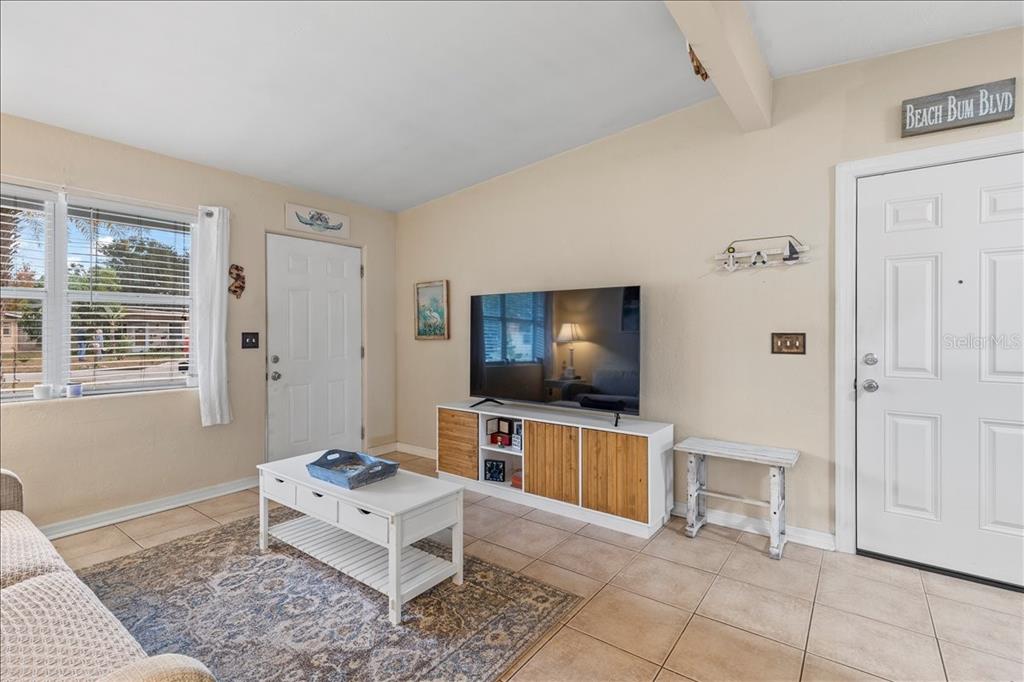 A living room features tile floors, a television on a wooden console, and two doors — 450 CARD AVENUE, HOLLY HILL, FL
