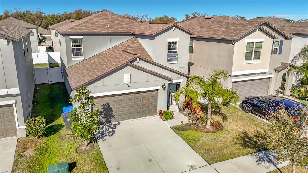 An elevated exterior view of a two-story suburban house with a brown shingled roof — 4211 ROMANO BUSCIGLIO STREET, TAMPA, FL