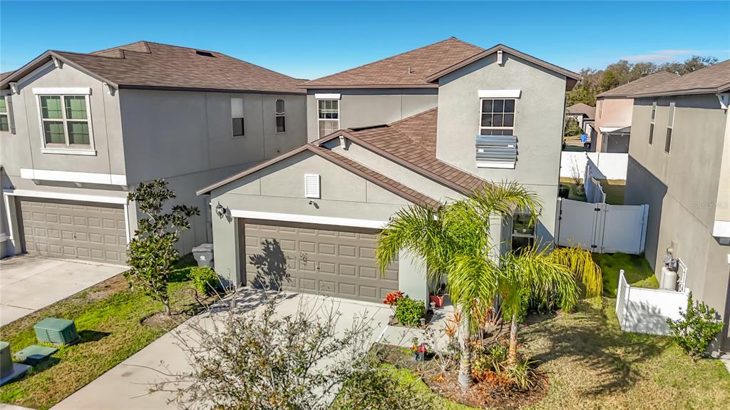 An exterior view of a two-story suburban house with a brown roof and garage — 4211 ROMANO BUSCIGLIO STREET, TAMPA, FL