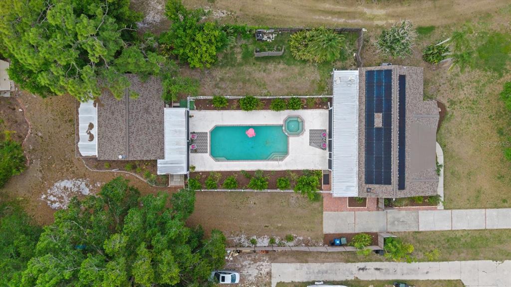 An aerial view shows a house with a swimming pool, spa, and solar panels — 5868 DENISON DRIVE, VENICE, FL